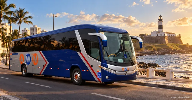 Ônibus da AWM na orla de Salvador ao entardecer, com o Farol da Barra ao fundo (imagem ilustrativa)
